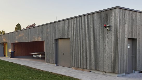 Außenansicht der Umkleidekabinen des Freibads Altheim in einer modernen Holzfassade