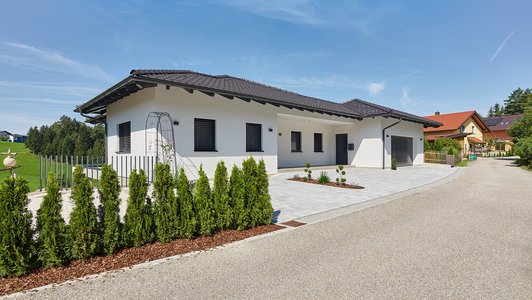 Massives Familienhaus mit Veranda - Außenansicht schräg mit Garage