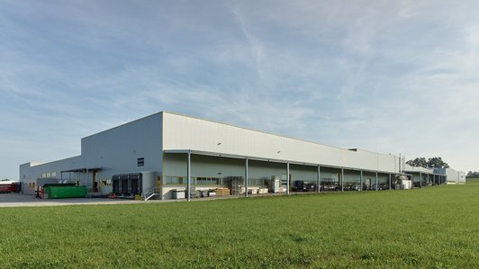 Rückansicht der Lugstein Produktionshalle, mit Beladebereich und grünem Außenbereich