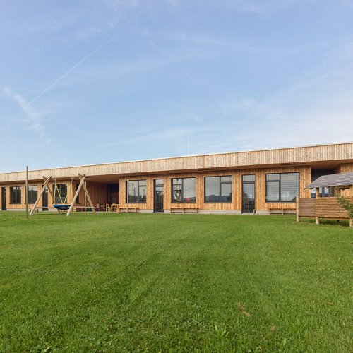 Außenansicht der Sonderschule Mattighofen mit Spielplatz im Vordergrund.