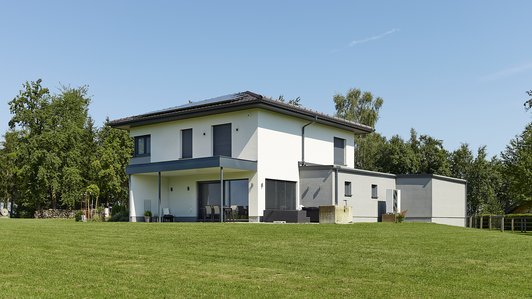 Kompaktes Familienhaus mit Garage - Seitansicht Garten