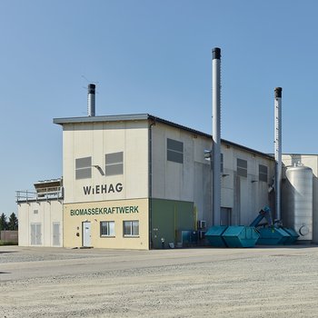 Biomassekraftwerk von WIEHAG mit Schornsteinen und Werkstatt im Hintergrund