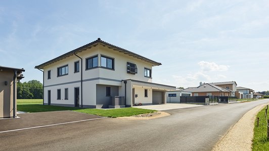 Heller und zeitloser Ziegelbau - Außenansicht mit Straße und Einfahrt
