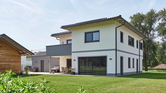 Heller und zeitloser Ziegelbau - Außenansicht mit Garten