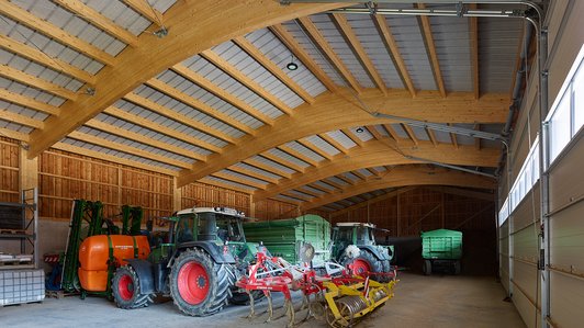 Rustikale Landwirtschaftshalle aus Holz - Innenansicht mit Traktoren