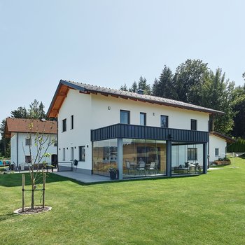 Massivhaus aus Ziegel und Holz mit Wintergarten