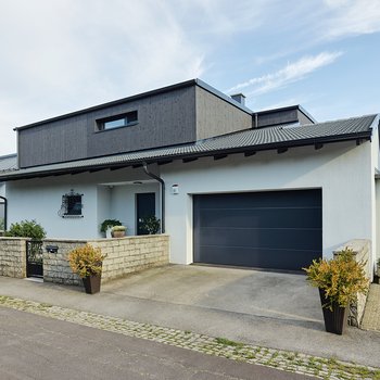 Moderner Holzbau mit Balkon - Außenansicht mit Garage