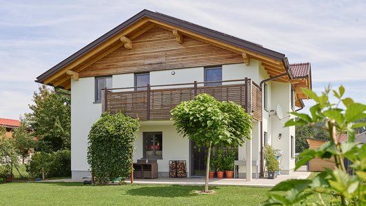 Familienhaus aus Massivholz - Außenansicht mit Garten