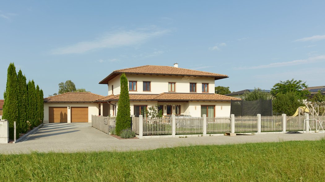 Blick auf das Haus mit umzäunten Garten
