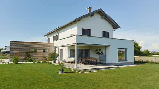 Moderner Ziegelbau in Alleinlage mit Holz-Einfahrt - Außenansicht mit Garten