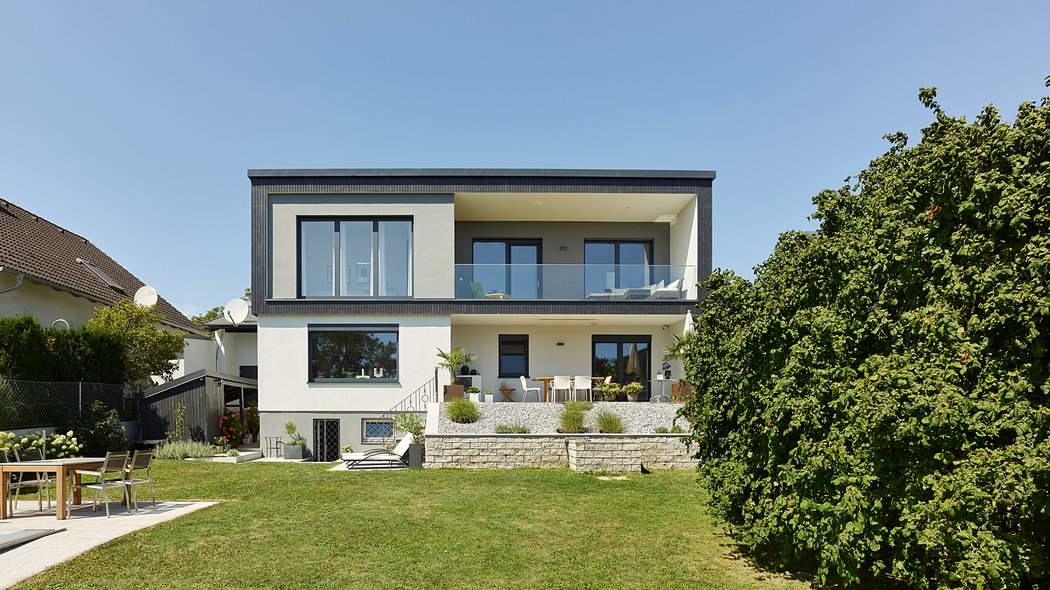 Moderner Holzbau mit Balkon - Gartenansicht