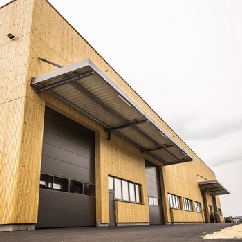 Moderne Lagerhalle mit Holzverkleidung und großem Tor