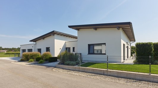 Seitliche Ansicht des Flachdach-Bungalows mit Straße im Vordergrund