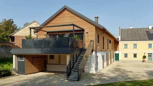 Einfamilienhaus im modernen Holzbaustil mit breiter Veranda und Außentreppe