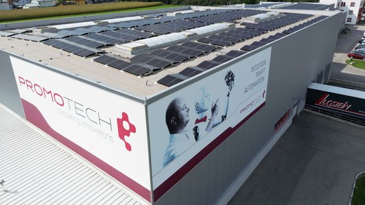 Promotech-Gebäude mit Solaranlagen auf dem Dach, Seitenansicht mit großem Logo