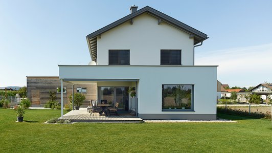Moderner Ziegelbau in Alleinlage mit Holz-Einfahrt - Seitansicht Außen mit Garten und Terrasse